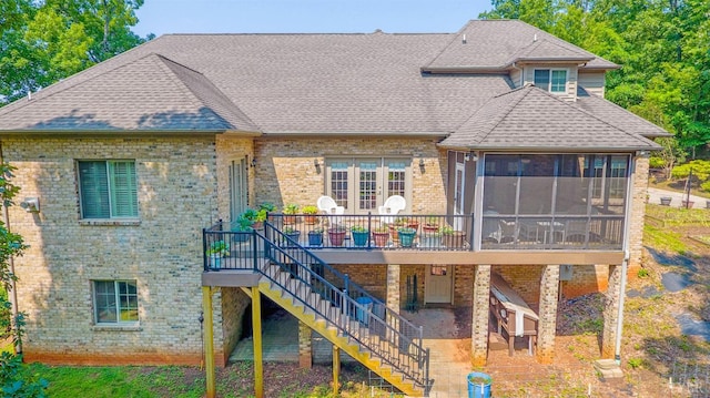 rear view of property with brick siding, stairway, a sunroom, and a patio