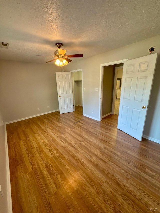 511 Bent Oak Ct, Lynchburg, VA 24502 - unfurnished bedroom with wood finished floors, a textured ceiling, ceiling fan, and a walk in closet