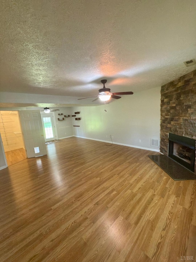 511 Bent Oak Ct, Lynchburg, VA 24502 - unfurnished living room with a textured ceiling, wood finished floors, ceiling fan, and a fireplace