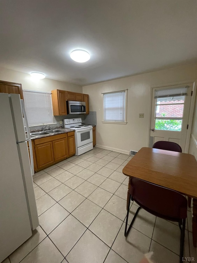 609 Hood St, Lynchburg, VA 24501 - kitchen with white appliances, a sink, light tile patterned flooring, dark countertops, and decorative backsplash