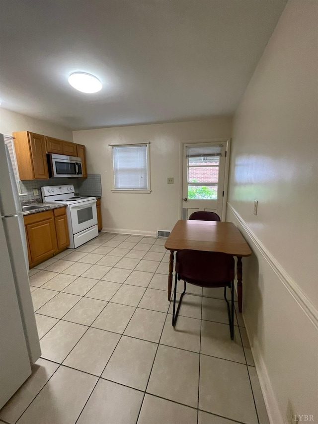 609 Hood St, Lynchburg, VA 24501 - kitchen featuring white appliances, light tile patterned floors, brown cabinets, and baseboards