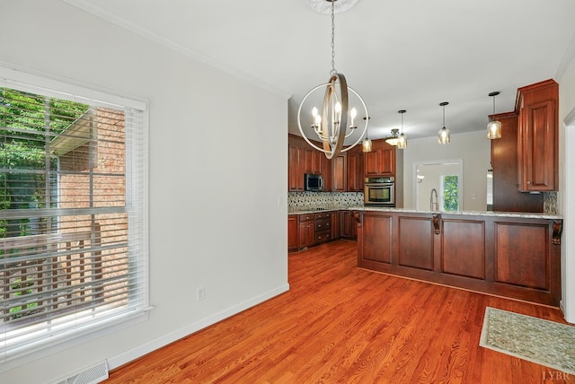 103 Waterton Dr, Lynchburg, VA 24503 - kitchen featuring appliances with stainless steel finishes, a chandelier, a peninsula, crown molding, and backsplash