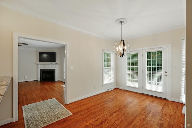 103 Waterton Dr, Lynchburg, VA 24503 - unfurnished dining area with a chandelier, wood finished floors, crown molding, and a fireplace with flush hearth