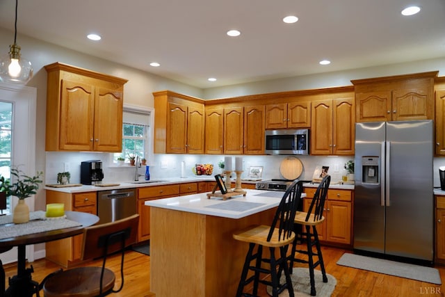 1061 Cedar Sky Ct, Forest, VA 24551 - kitchen featuring appliances with stainless steel finishes, a sink, light countertops, a center island, and brown cabinets