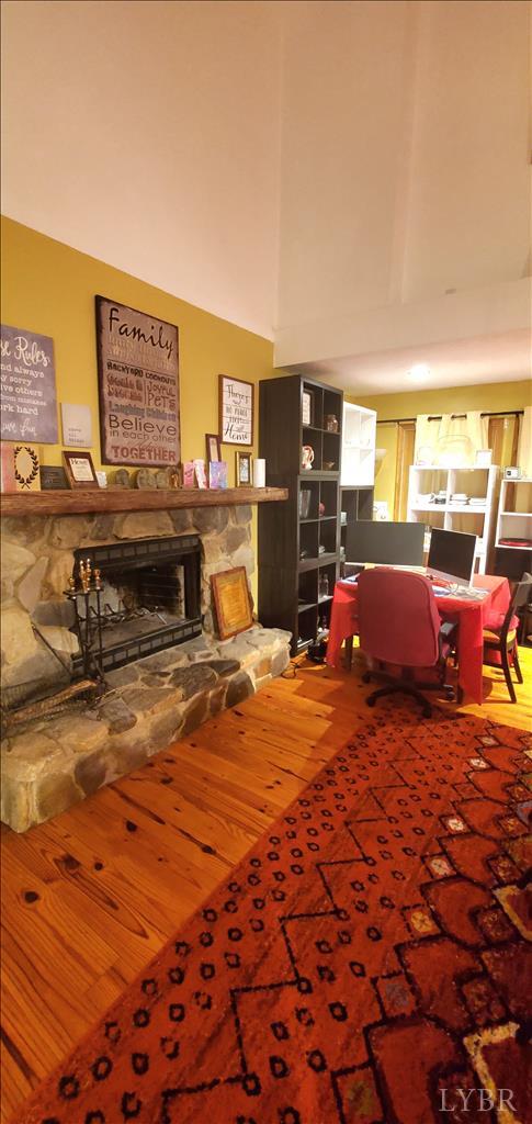 2995 Bear Creek Rd, Rustburg, VA 24588 - living area with wood finished floors, a towering ceiling, a fireplace, and a desk