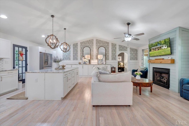 1369 Timberlake Dr, Lynchburg, VA 24502 - living area featuring a fireplace, a decorative wall, arched walkways, a chandelier, and light wood finished floors