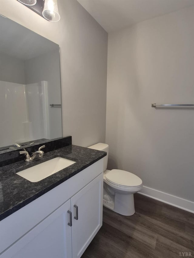 66 Pelt Ln, Evington, VA 24550 - full bathroom featuring wood finished floors, vanity, toilet, baseboards, and a shower