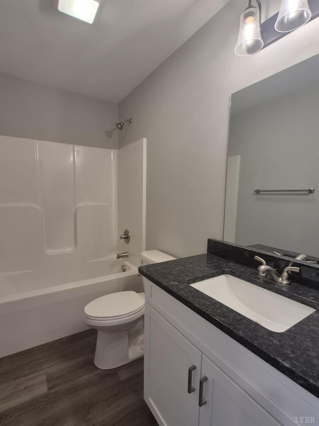 66 Pelt Ln, Evington, VA 24550 - bathroom featuring toilet, vanity, wood finished floors, and shower / washtub combination