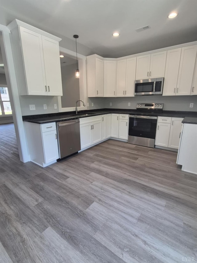 66 Pelt Ln, Evington, VA 24550 - kitchen featuring appliances with stainless steel finishes, recessed lighting, dark countertops, white cabinetry, and a sink