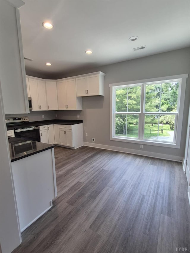 66 Pelt Ln, Evington, VA 24550 - kitchen featuring electric range, baseboards, white cabinetry, dark countertops, and dark wood finished floors