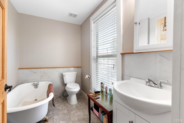 1801 Floyd St, Lynchburg, VA 24501 - bathroom with a soaking tub, vanity, toilet, tile walls, and a wainscoted wall