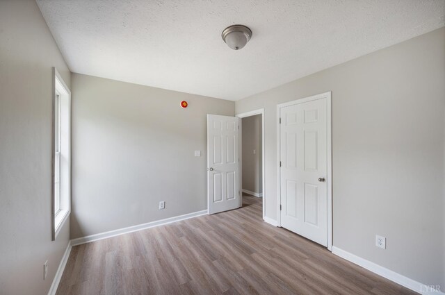 100 Creston Oaks Ct, Forest, VA 24551 - unfurnished bedroom featuring wood finished floors, baseboards, multiple windows, and a textured ceiling