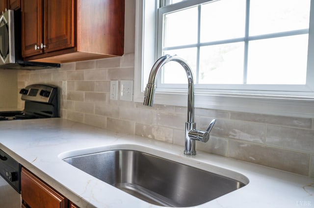 100 Creston Oaks Ct, Forest, VA 24551 - kitchen view of a sink, stainless steel appliances, brown cabinetry, tasteful backsplash, and light stone countertops