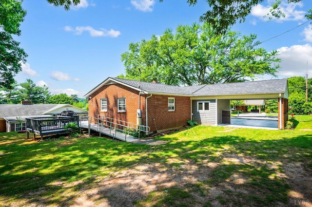 206 Huffmond St, Gretna, VA 24557 - back of house with a carport, brick siding, a wooden deck, and a yard