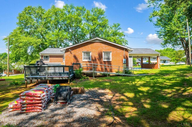 206 Huffmond St, Gretna, VA 24557 - rear view of house with brick siding, a deck, and a lawn