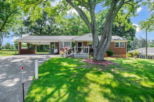 206 Huffmond St, Gretna, VA 24557 - single story home featuring asphalt driveway, brick siding, a front yard, covered porch, and a carport