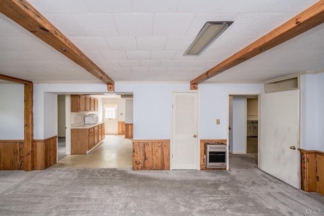 2207 Indian Hill Rd, Lynchburg, VA 24503 - unfurnished living room with heating unit, wood walls, beamed ceiling, light carpet, and wainscoting
