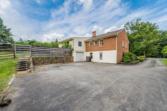 2207 Indian Hill Rd, Lynchburg, VA 24503 - back of house with a garage, asphalt driveway, a chimney, and brick siding