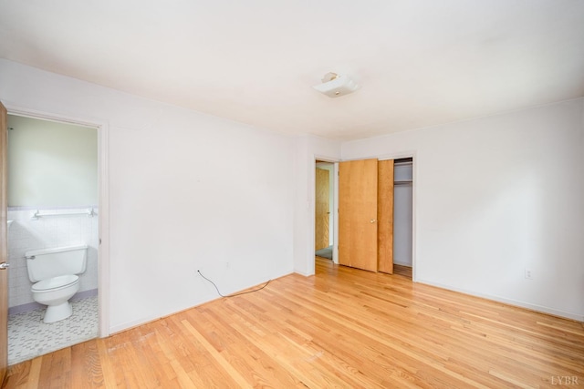 2207 Indian Hill Rd, Lynchburg, VA 24503 - unfurnished bedroom with light wood finished floors, a closet, ensuite bath, and tile walls