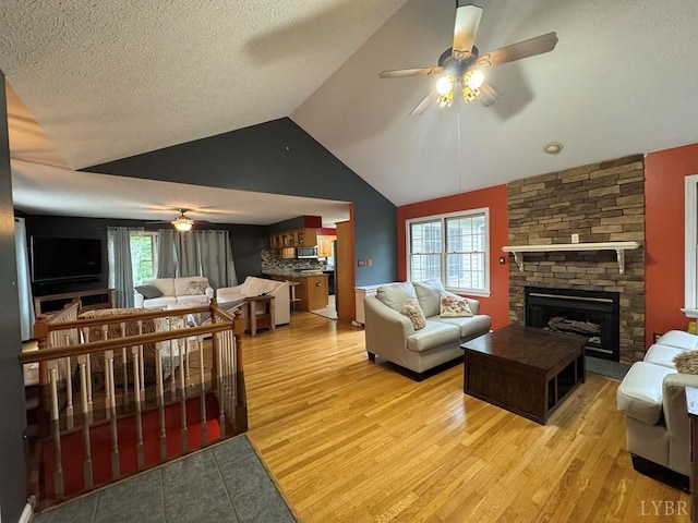 8 Northgate Ct, Lynch Station, VA 24571 - living area with ceiling fan, a fireplace, vaulted ceiling, light wood-style floors, and a textured ceiling