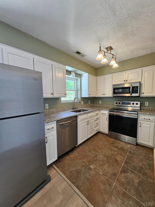 542 Leesville Rd Unit 104, Lynchburg, VA 24502 - kitchen with stainless steel appliances, white cabinets, a textured ceiling, light stone counters, and hanging light fixtures