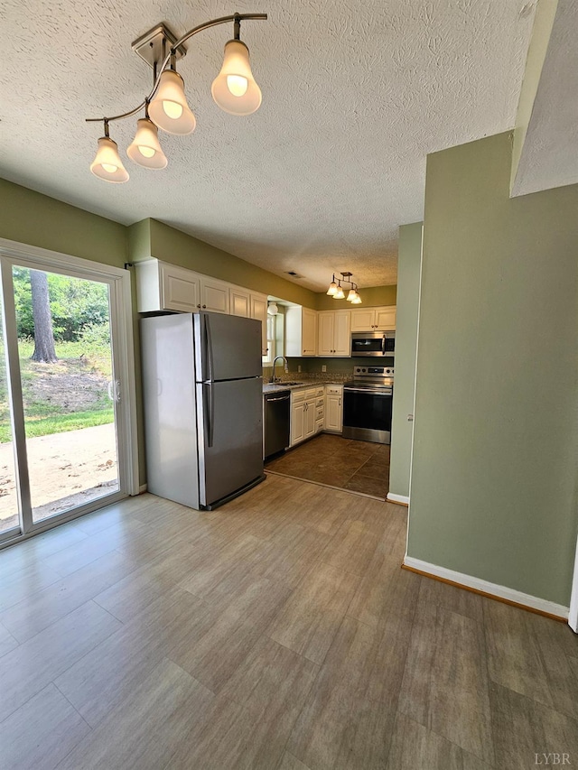 542 Leesville Rd Unit 104, Lynchburg, VA 24502 - kitchen with appliances with stainless steel finishes, a textured ceiling, dark wood finished floors, a chandelier, and white cabinetry