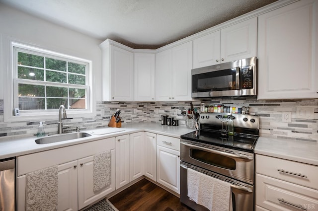 1168 Macon Loop, Lynchburg, VA 24503 - kitchen with stainless steel appliances, decorative backsplash, white cabinetry, light countertops, and a textured ceiling