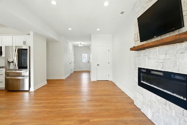 1036 Brownstone Dr, Forest, VA 24551 - unfurnished living room featuring a stone fireplace, light wood-style flooring, and recessed lighting