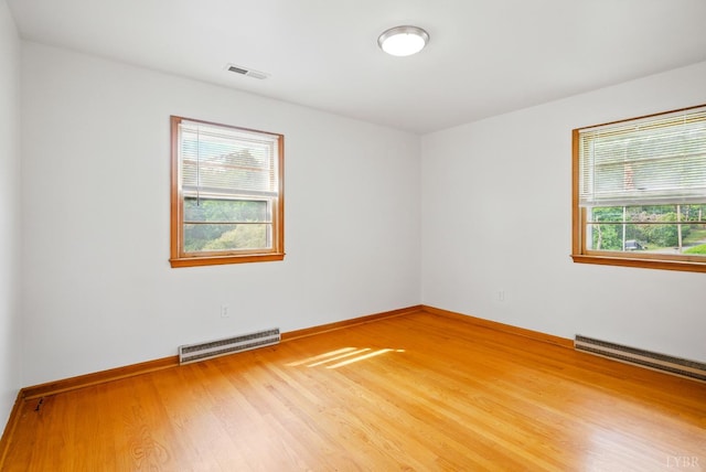 102 SE St, Brookneal, VA 24528 - spare room with wood finished floors, plenty of natural light, and a baseboard heating unit