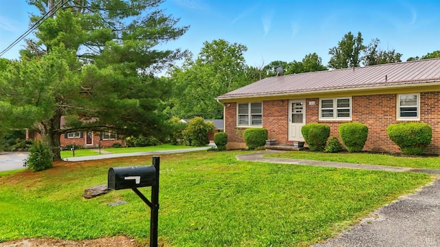 102 SE St, Brookneal, VA 24528 - view of front of house with brick siding, a front yard, and a metal roof