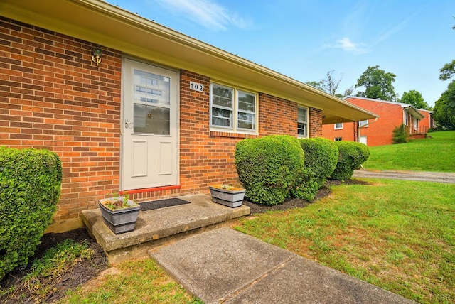 102 SE St, Brookneal, VA 24528 - doorway to property featuring a lawn and brick siding