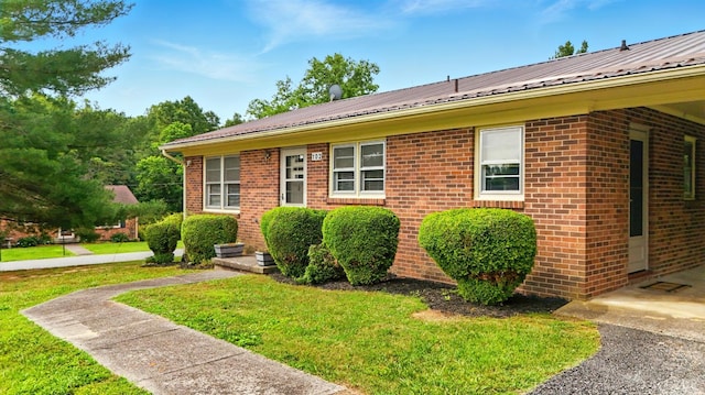 102 SE St, Brookneal, VA 24528 - view of front facade featuring brick siding, a front yard, and a metal roof