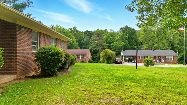 102 SE St, Brookneal, VA 24528 - view of grassy yard featuring driveway and a carport