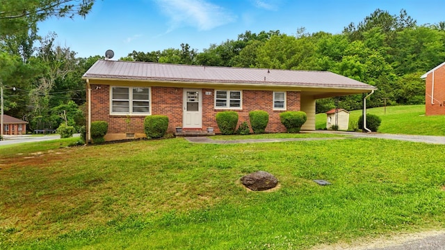 102 SE St, Brookneal, VA 24528 - view of front of home featuring a storage unit, driveway, a front lawn, an attached carport, and brick siding