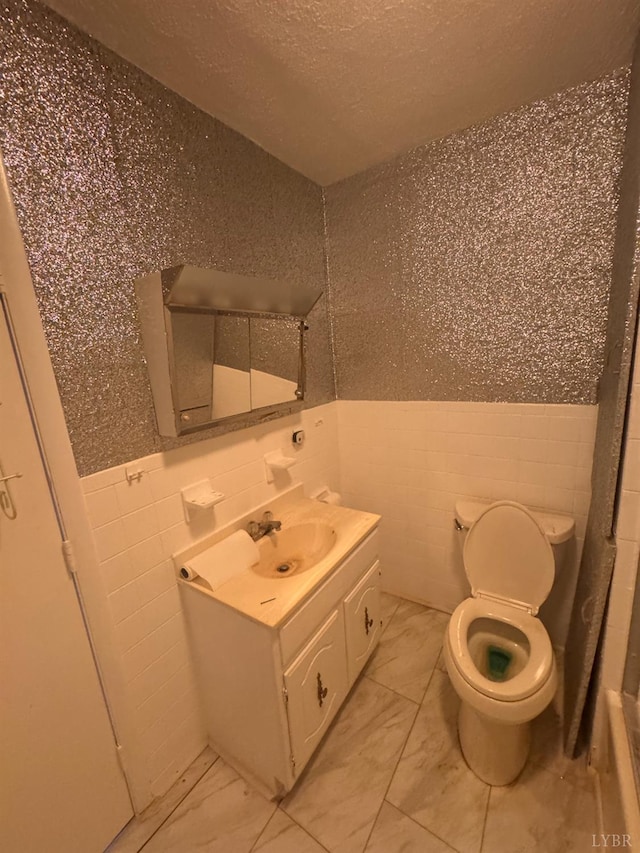 512 Polk St, Lynchburg, VA 24504 - bathroom featuring tile walls, vanity, marble look tile flooring, a textured ceiling, and wainscoting