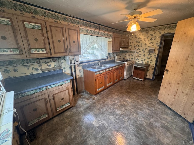 512 Polk St, Lynchburg, VA 24504 - kitchen featuring white gas range, brown cabinetry, wallpapered walls, ceiling fan, and under cabinet range hood