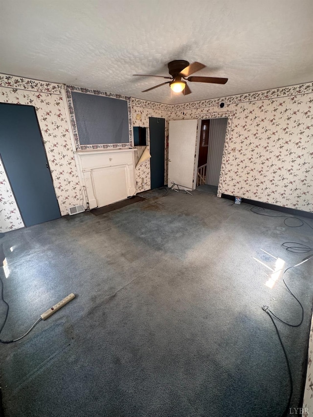 512 Polk St, Lynchburg, VA 24504 - unfurnished living room with wallpapered walls, ceiling fan, dark carpet, and a textured ceiling