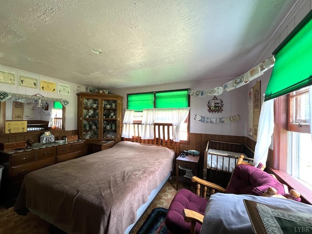 8288 Red House Rd, Phenix, VA 23959 - bedroom featuring a textured ceiling, wood walls, and a wainscoted wall
