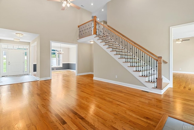 1290 Ivy Creek Dr, Forest, VA 24551 - unfurnished living room featuring a ceiling fan, high vaulted ceiling, wood finished floors, and stairway