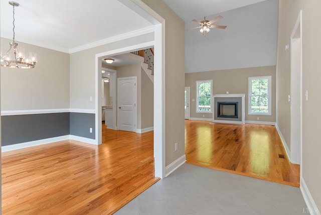 1290 Ivy Creek Dr, Forest, VA 24551 - unfurnished living room with a chandelier, a ceiling fan, a fireplace, wood finished floors, and ornamental molding