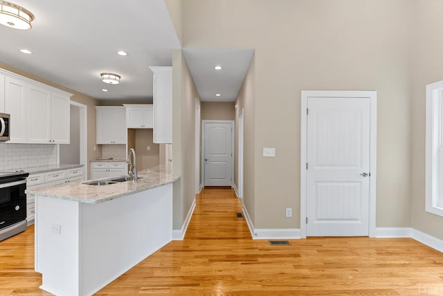 1290 Ivy Creek Dr, Forest, VA 24551 - kitchen featuring stainless steel appliances, white cabinets, light wood-style flooring, tasteful backsplash, and recessed lighting