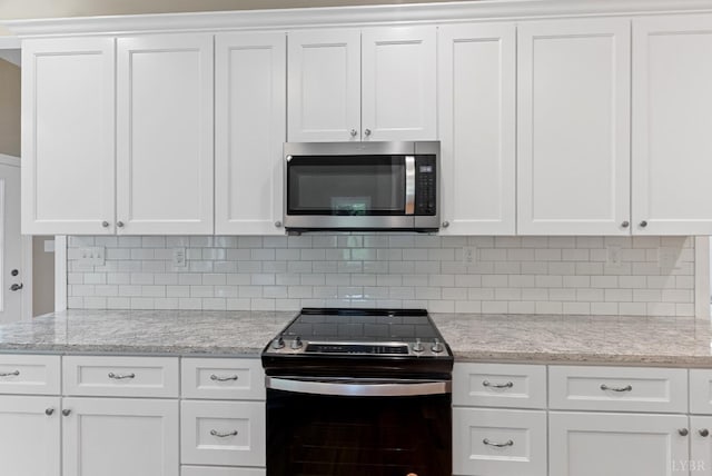 1290 Ivy Creek Dr, Forest, VA 24551 - kitchen featuring stainless steel microwave, range with electric cooktop, white cabinetry, and tasteful backsplash