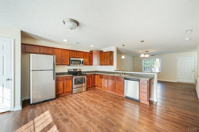 106 Colonnade St, Lynchburg, VA 24502 - kitchen with stainless steel appliances, a peninsula, light wood finished floors, brown cabinets, and recessed lighting