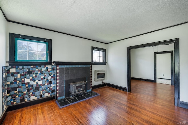 1614 Early St, Lynchburg, VA 24503 - unfurnished living room featuring a wood stove, heating unit, a textured ceiling, wood finished floors, and crown molding