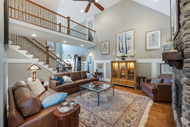 1424 Lake Manor Dr, Forest, VA 24551 - living room with a stone fireplace, a towering ceiling, a ceiling fan, stairway, and wood finished floors