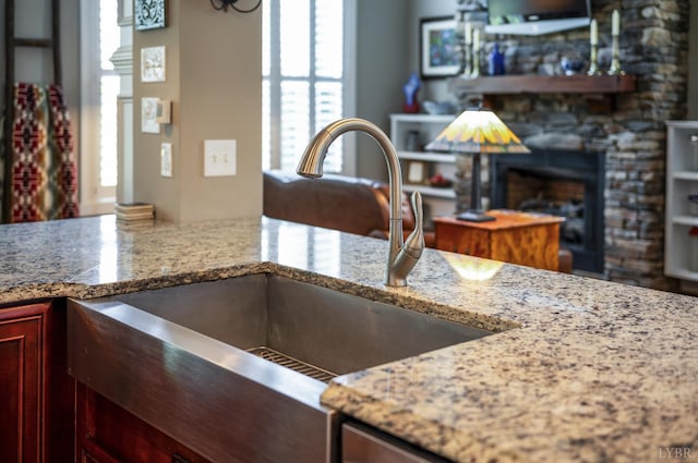 1424 Lake Manor Dr, Forest, VA 24551 - kitchen view of dark brown cabinets, a fireplace, and light stone countertops
