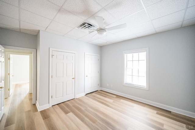 1313 Enterprise, Lynchburg, VA 24502 - unfurnished bedroom with light wood-style flooring, a drop ceiling, a ceiling fan, and two closets