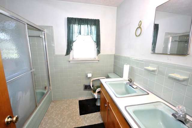 315 Cork St, Lynchburg, VA 24503 - bathroom featuring tile walls, bath / shower combo with glass door, double vanity, and wainscoting