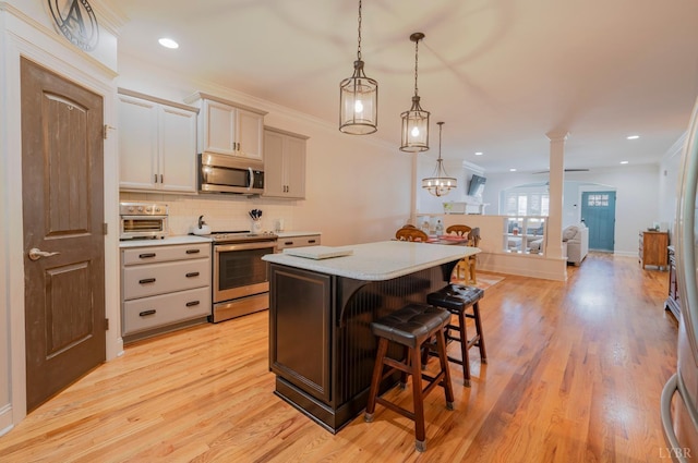 1507 Helmsdale Dr, Forest, VA 24551 - kitchen featuring stainless steel appliances, a kitchen island, a kitchen breakfast bar, light countertops, and tasteful backsplash