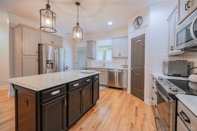 1507 Helmsdale Dr, Forest, VA 24551 - kitchen with appliances with stainless steel finishes, crown molding, hanging light fixtures, light wood-style flooring, and backsplash